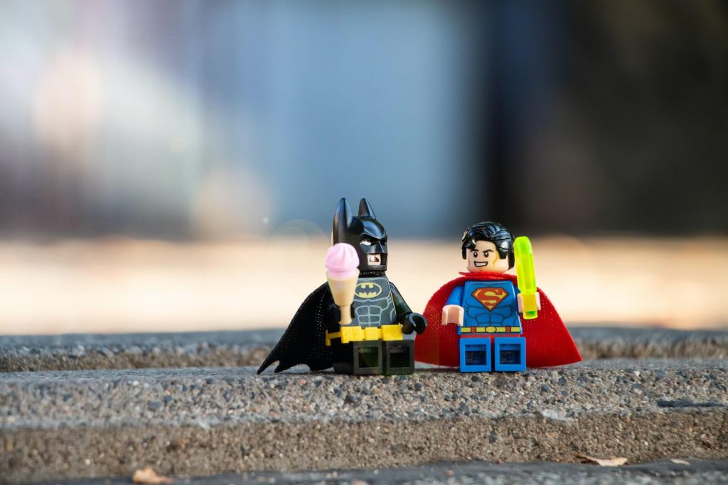 Una imagen de dos figuras de LEGO que representan a los icónicos personajes de DC, Batman y Superman, hechas con bloques de construcción de colores.